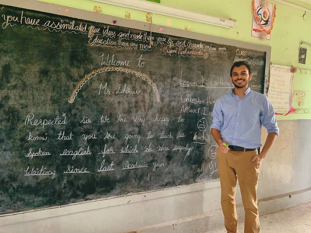Student standing in front of blackboard