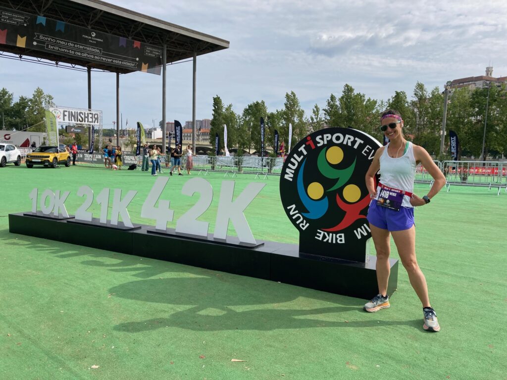 woman standing next to 10k running sign 