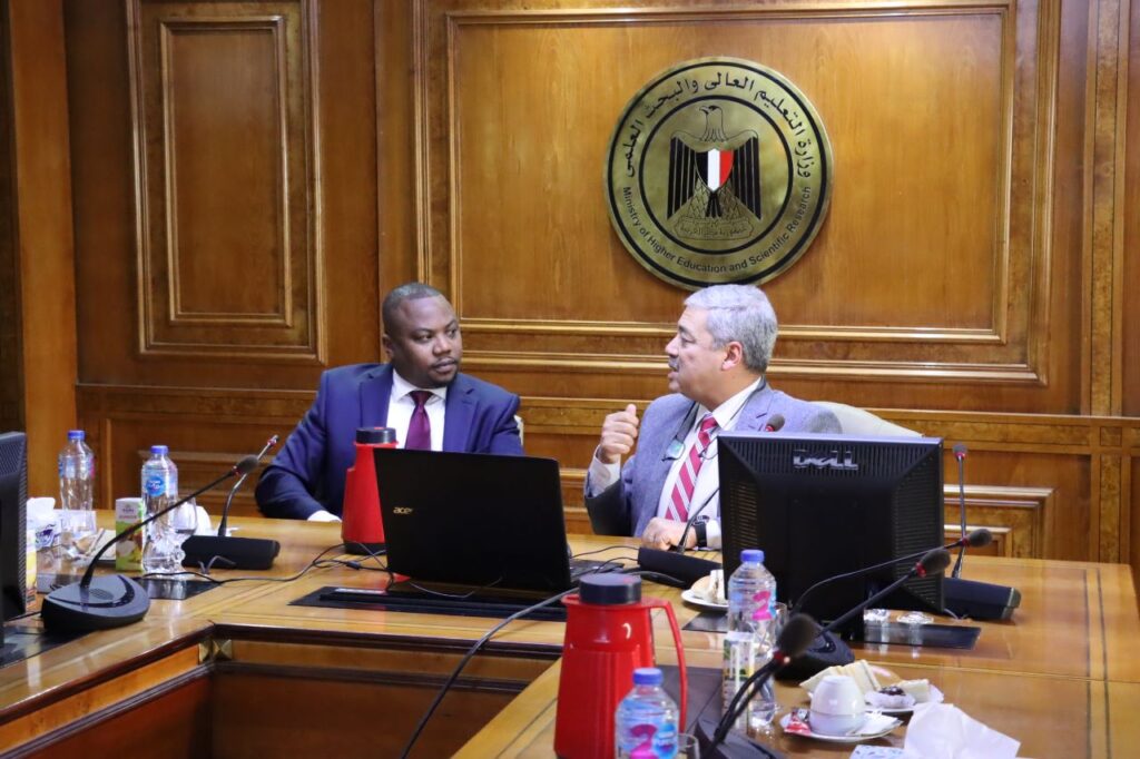 Two men sitting at board talking