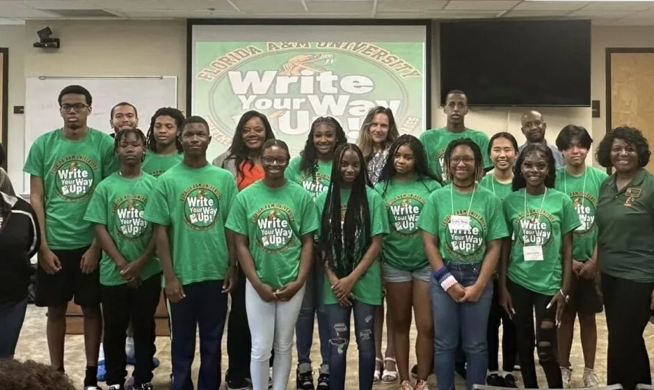 High School students standing in front of projector with Professor. 