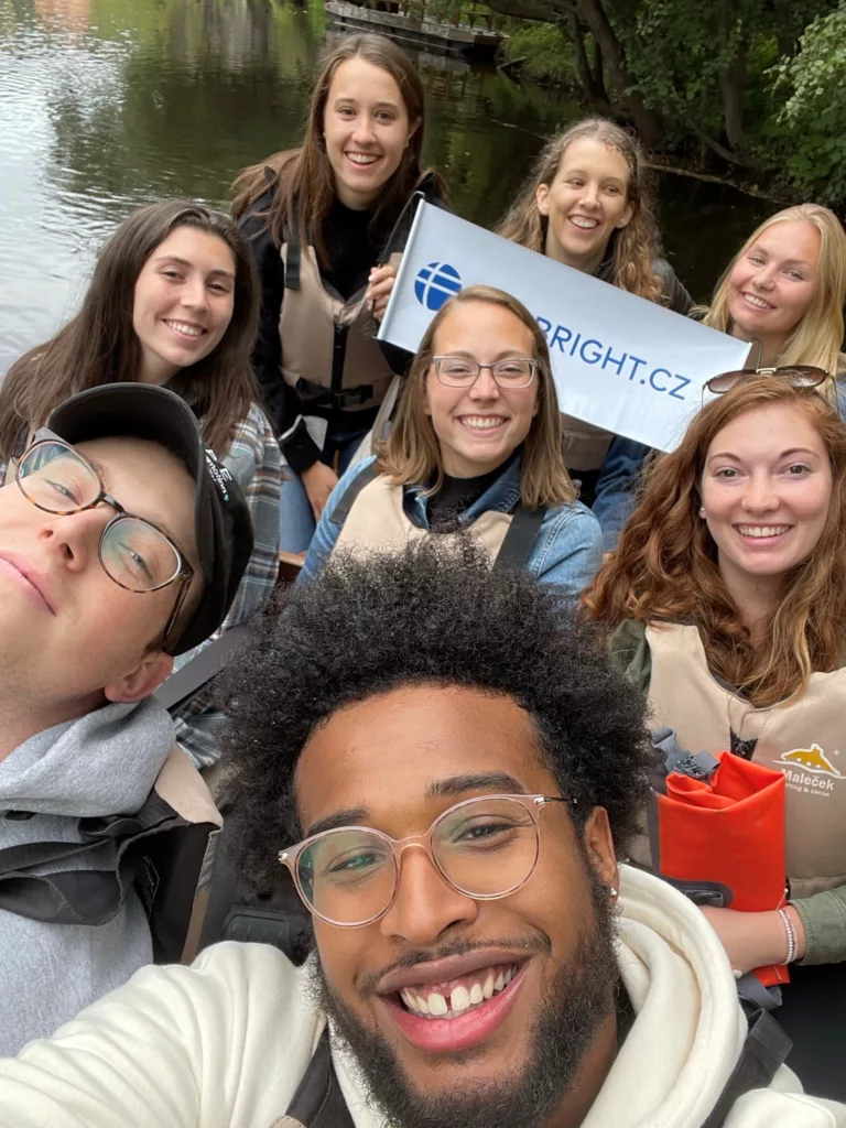 Group of Fulbright participants taking a selfie by river with Fulbright sign.