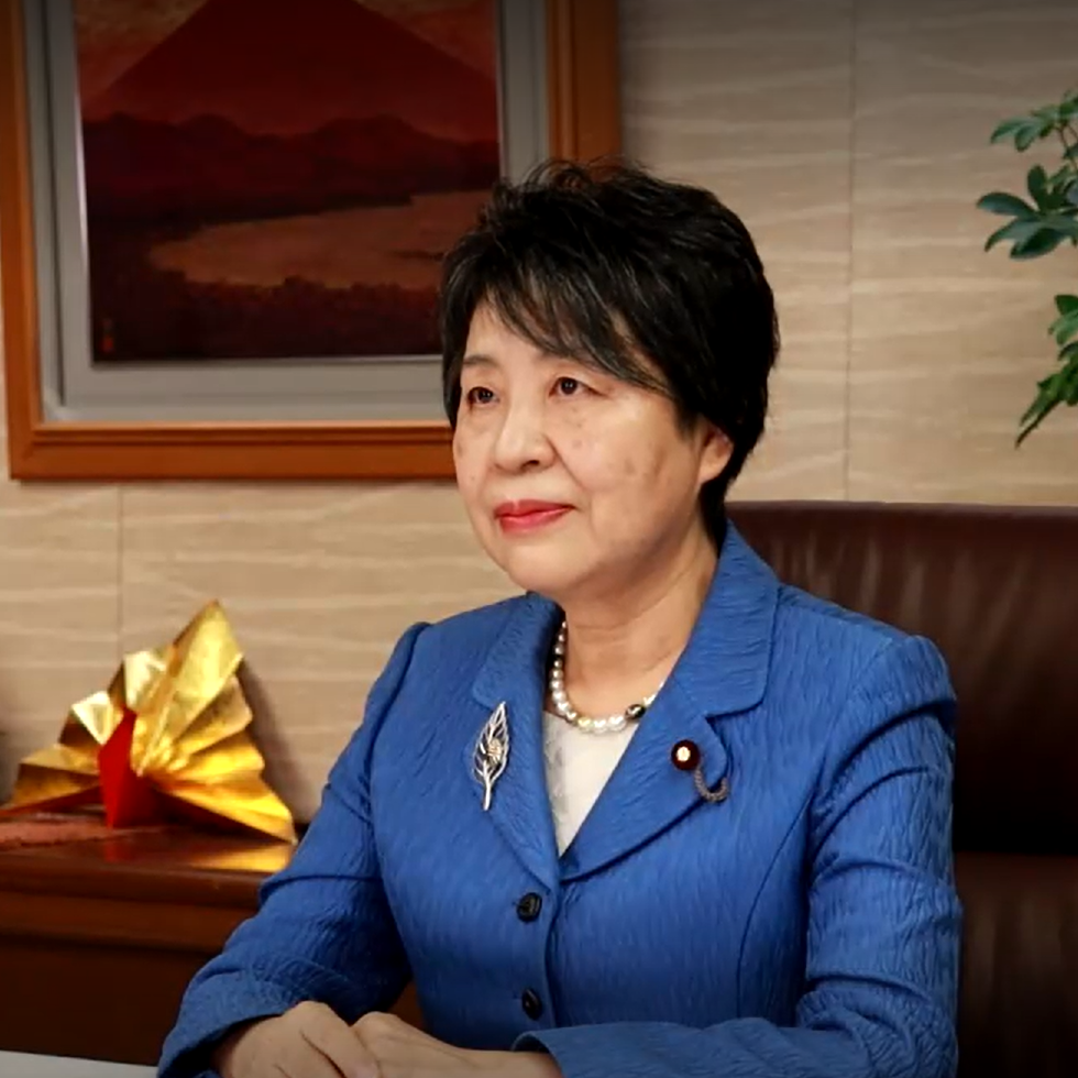Yoko Kamikawa sitting at desk making remarks.