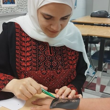 Fulbrighter doing henna on a students hand