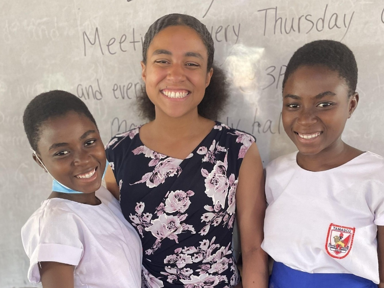 Two students and Fulbrighter standing in front of whiteboard