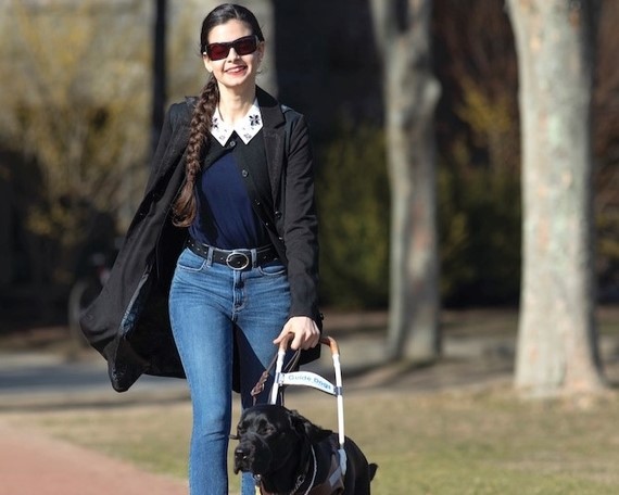 Aria Mia Loberti walking in London park with guide dog