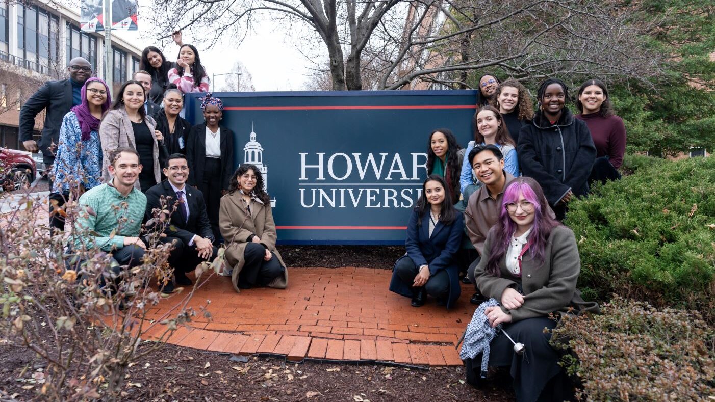 Fulbright Alumni Ambassadors posing on either side of Howard University sign.