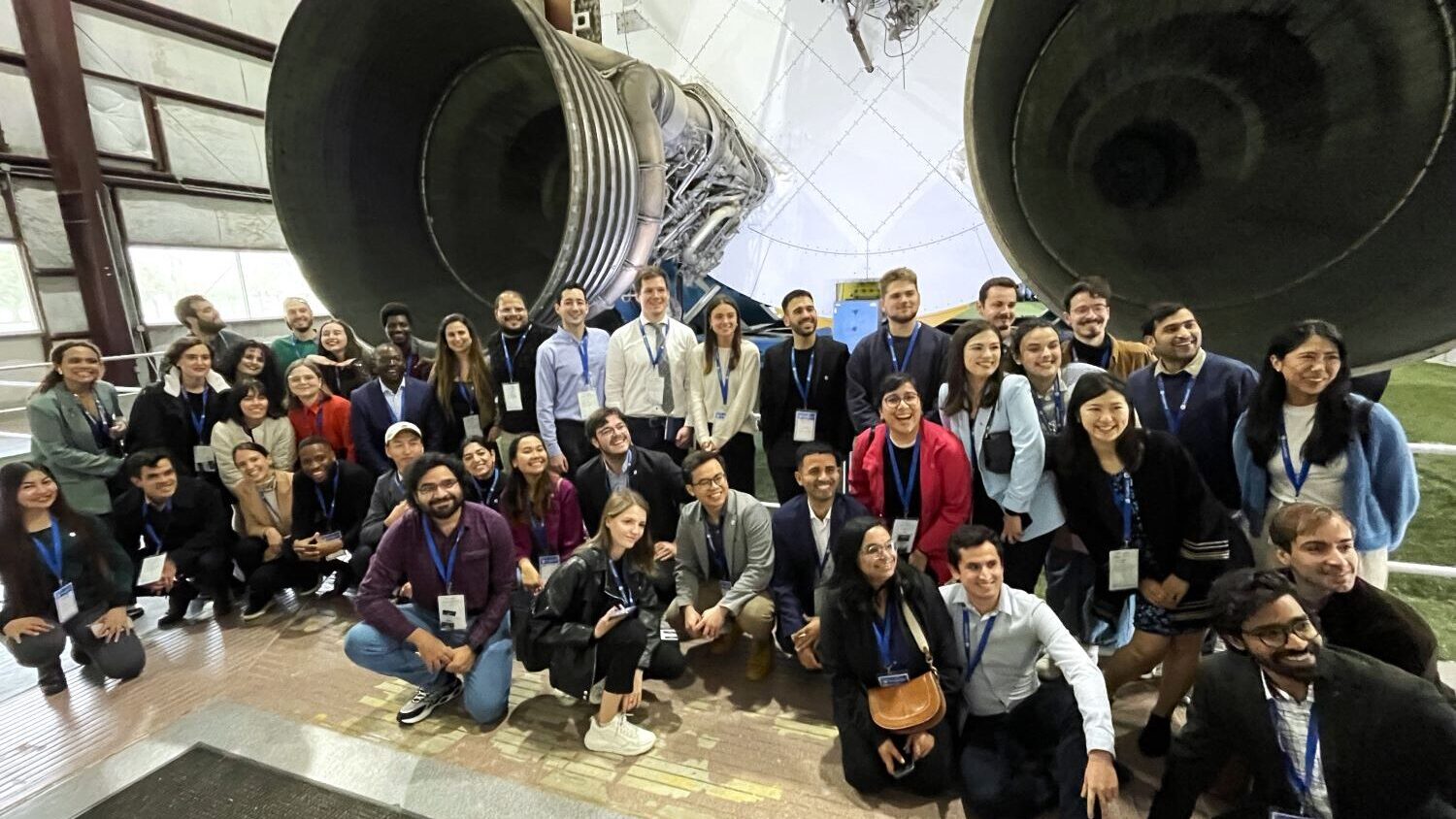 Fulbrighters posing in front of rocket engines at NASA