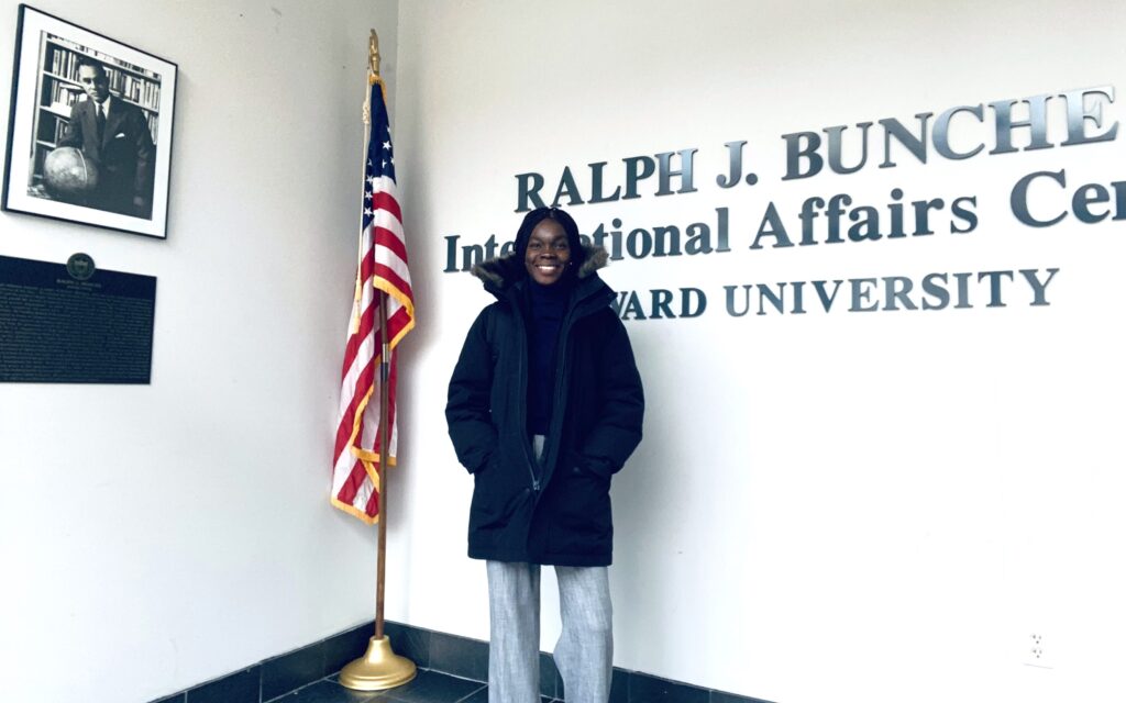 Addadzi-Koom standing in front of sign for International Affairs Center at Howard University
