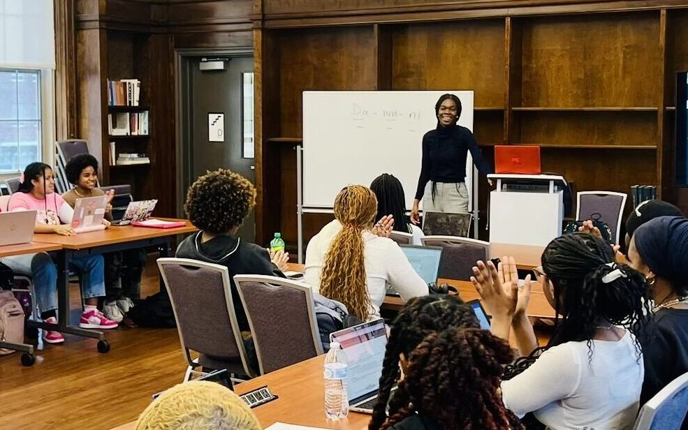 Addadzi-Koom teaching to students sat at desks in front of white board at Howard University