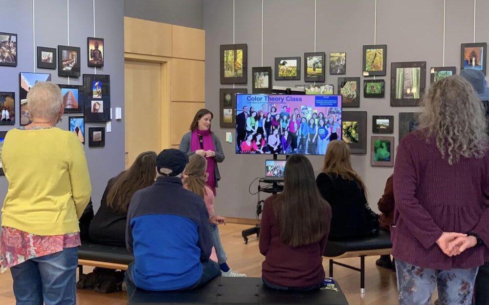 Heather Jones presenting in front of group of seated people at gallery