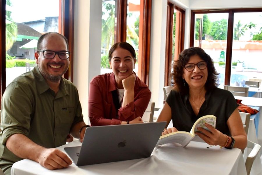 Three Amazonian Scholars sitting around table working on laptop