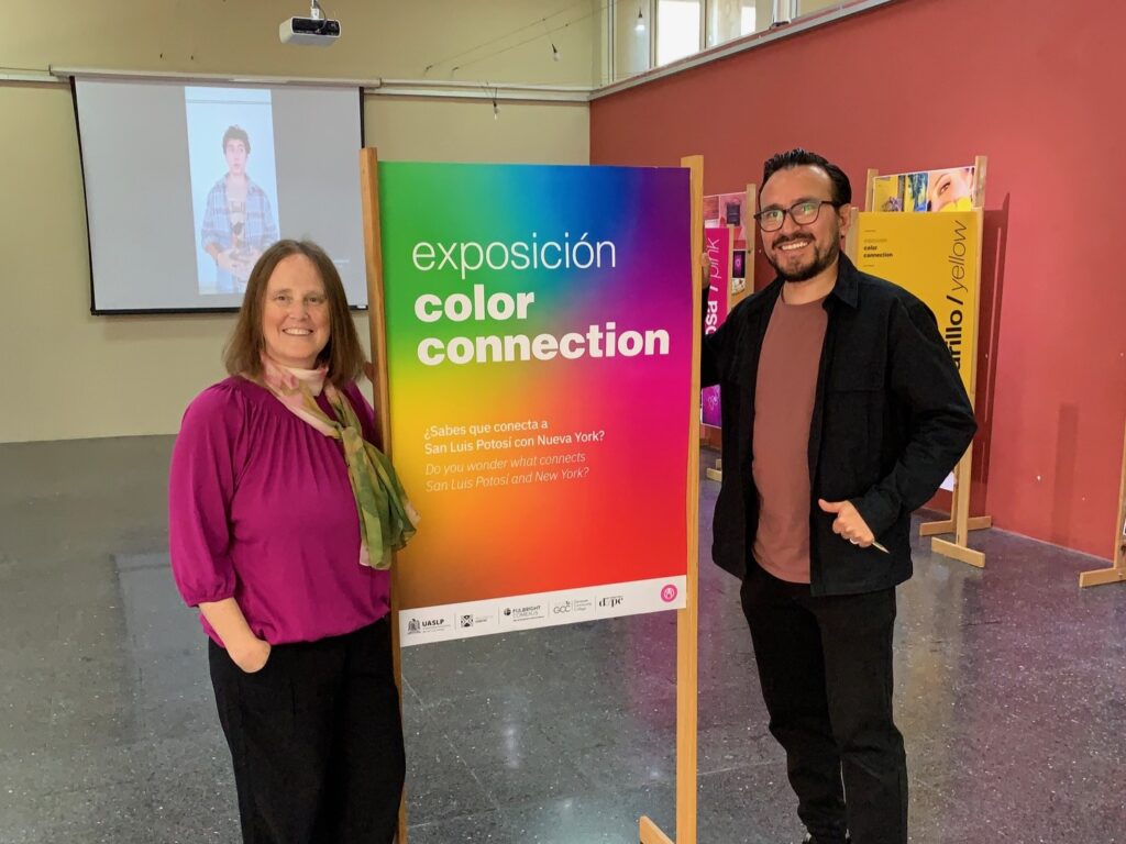 Heather Jones standing by side of sign for exhibit with man