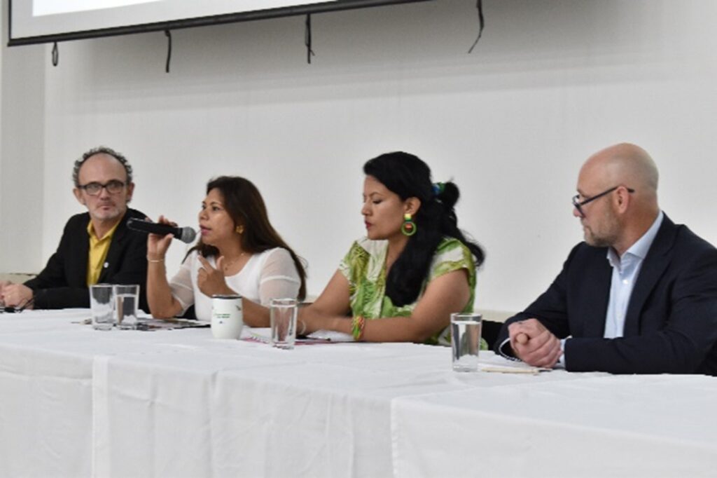 Four Amazonian Scholars sitting at table leading a panel