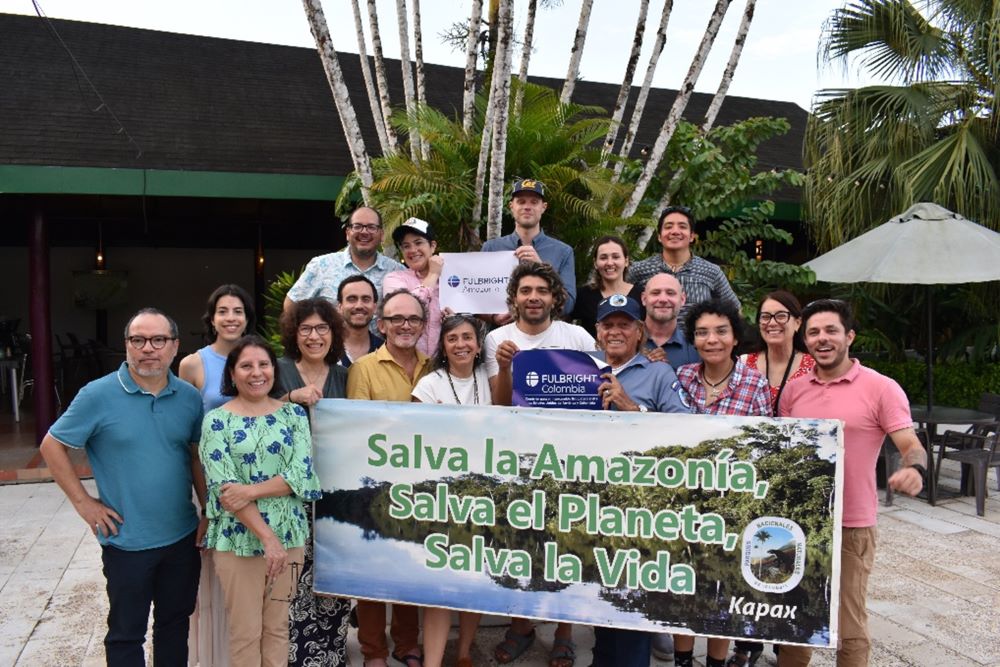 Group of Amazonian scholars with Portuguese sign saying Save the Amazon