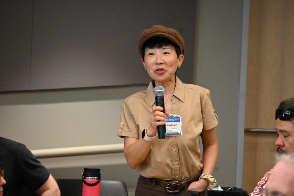 Scholar Liaison standing up and speaking into microphone