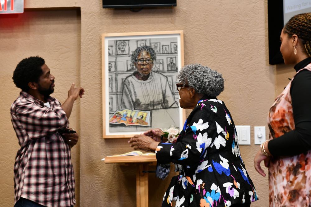 Sedrick Huckaby and Opal Lee looking at painting and talking