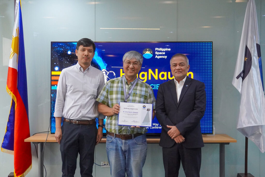 Image of three men, one holding a certificate, at a Philippine space agency event.